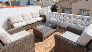 A rooftop terrace with wicker furniture and a white decorative fence. - CH Villa Africa La Marquesa Golf (Ciudad Quesada) (Ciudad Quesada)