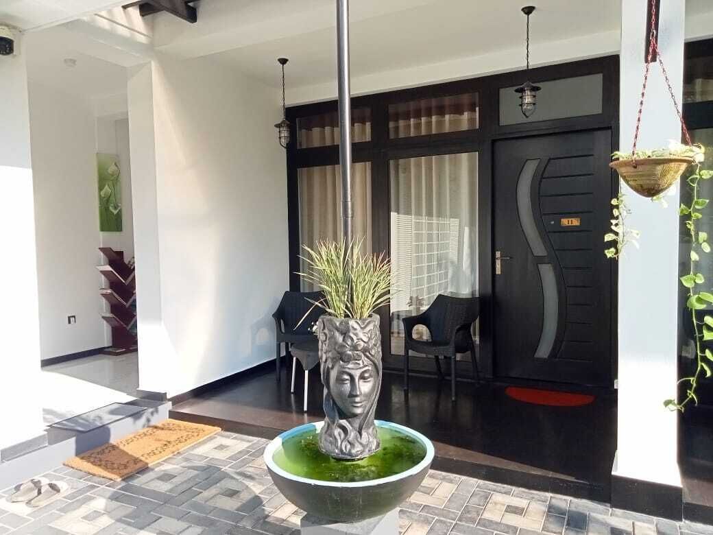 Un interior modern amb un bol decoratiu al centre, una escala i una zona de menjador amb cadires i taula.