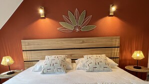 A neatly made bed with two pillows, a wooden headboard, and two bedside lamps. - T3 rénové avec balcon, vue montagne et Parking. (Cauterets)