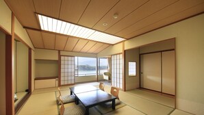 Ein traditioneller japanischer Raum mit Tatami-Boden, einem niedrigen Tisch und Schiebetüren.