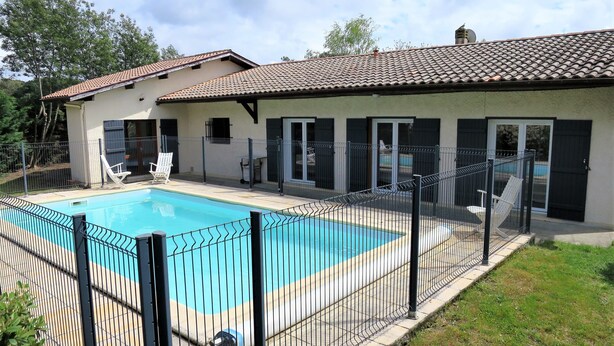 A residential property with a swimming pool, a fenced patio, and a house with a tiled roof. - Maison Spacieuse sur le Bassin D'arcachon (Lanton)