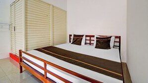 A single bed with a wooden frame, a white mattress, and a brown headboard. - Super OYO 3702 Homestay Bougenville Syariah (Lamongan)