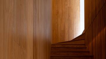 Una escalera de madera con diseño moderno que sube a un piso superior.
