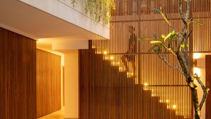 Ein modernes Interieur mit einer Holzhakenschrankwand, einem Betonboden und einem Blumentopf.