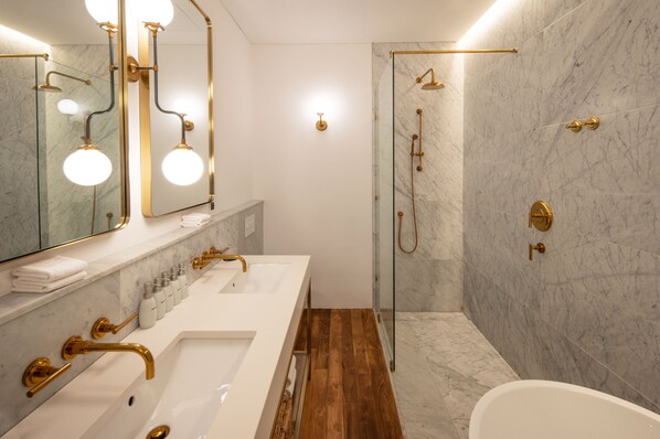A modern bathroom with two sinks, a bathtub, and a walk-in shower. - The Charleston (Galle)