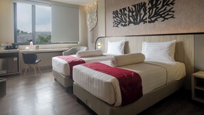 A hotel room with two beds, a desk, and a chair. - Gosyen Azana Hotel Salatiga (Salatiga)