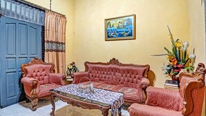Una habitación con un conjunto de sofá tradicional, una mesa estampada y un cuadro en la pared.