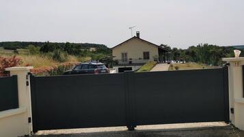 A gated entrance to a property with a house in the background.