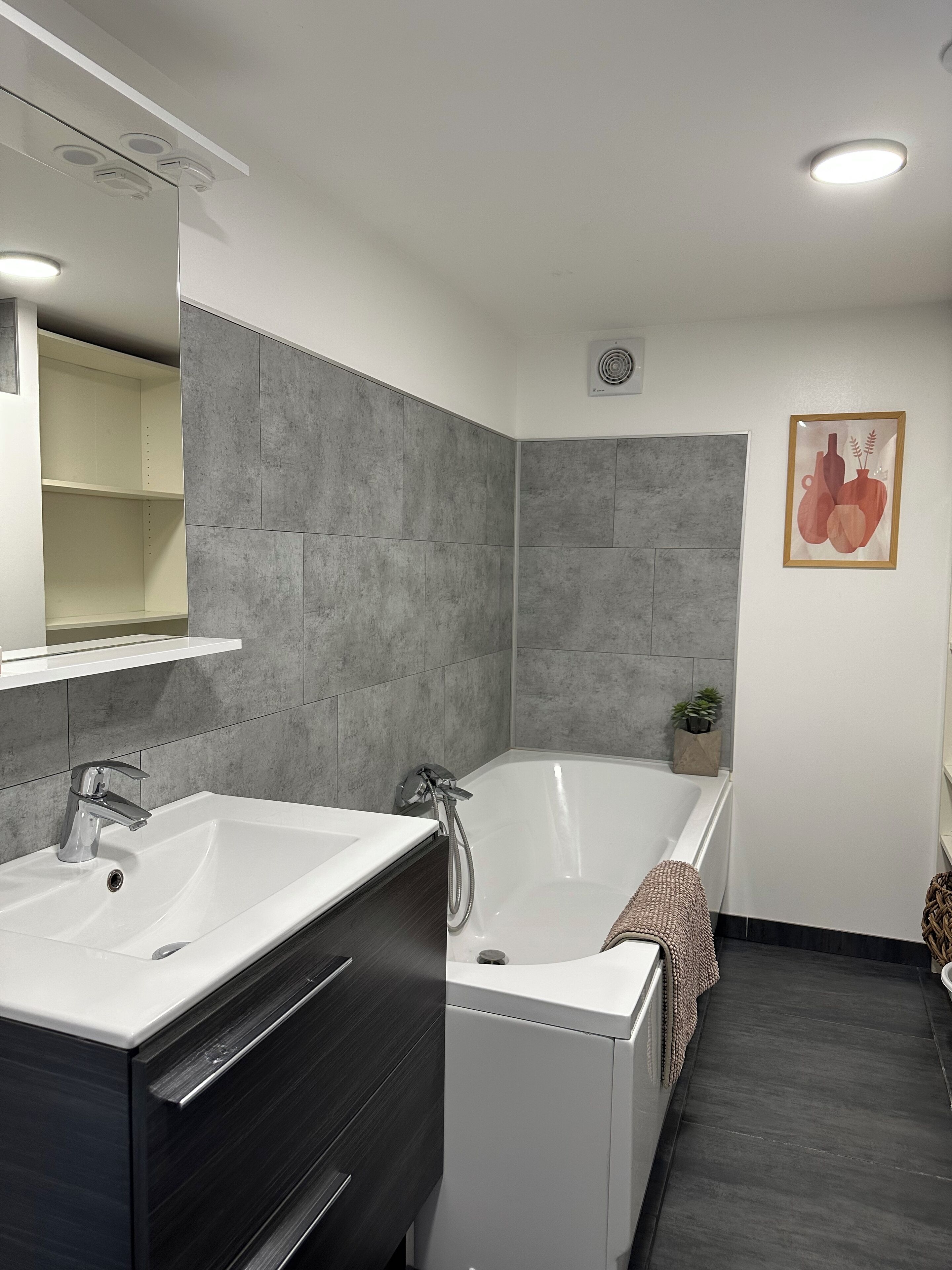 Une salle de bain moderne avec deux lavabos, une baignoire et une douche.