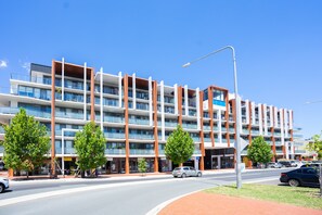 A multi-story hotel with a modern design, featuring balconies and a central courtyard.
