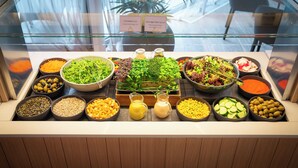 A salad bar with various greens, seeds, and dressings. - Normafa Hotel (Budapest)