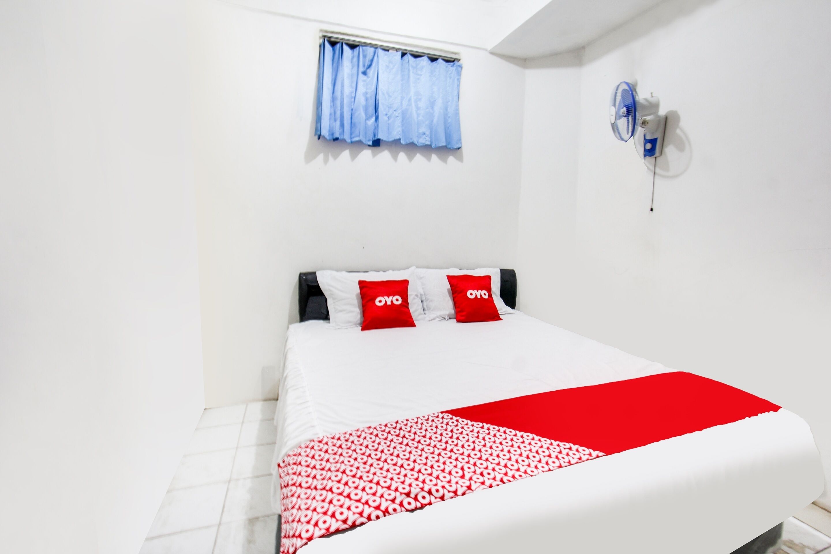 A neatly arranged bedroom with a bed, pillows, and a blanket.