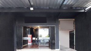 The entrance to an Apple Store with a modern design, featuring a glass door and a metal roof. - OYO 91391 Mutiara Syariah 3  (Mataram)