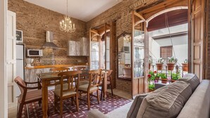 Una cucina accogliente con zona pranzo, mobili in legno e un balcone con piante in vaso.