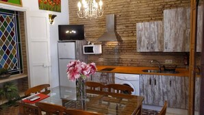 Una cucina moderna con forno a incasso, microonde e lavandino. C'è un tavolo da pranzo con sedie e un vaso di fiori.