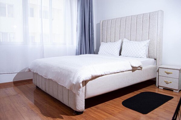 Relax in comfort with a large bed, tufted headboard, and bedside table with drawers.