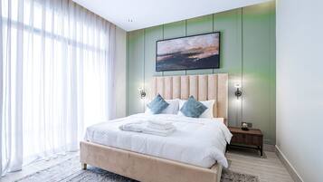 Una camera da letto moderna con un letto grande, una testiera, lampade da comodino e un quadro appeso al muro.