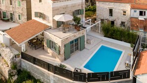 A two-story stone building with a swimming pool, outdoor seating, and a covered patio area. - Villa Mara Casa Rustica ZadarVillas (Korcula)