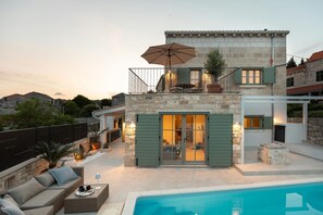 A two-story house with a pool, stone walls, and outdoor seating. - Villa Mara Casa Rustica ZadarVillas (Korcula)