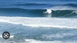 Vista del océano con olas y un surfista.