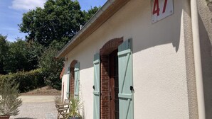 Ein Gebäude mit der Nummer 47, ein Kiesweg und Gartenmöbel.