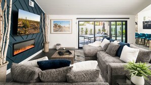 Una sala moderna con chimenea, un conjunto de sofás y un comedor con vistas.