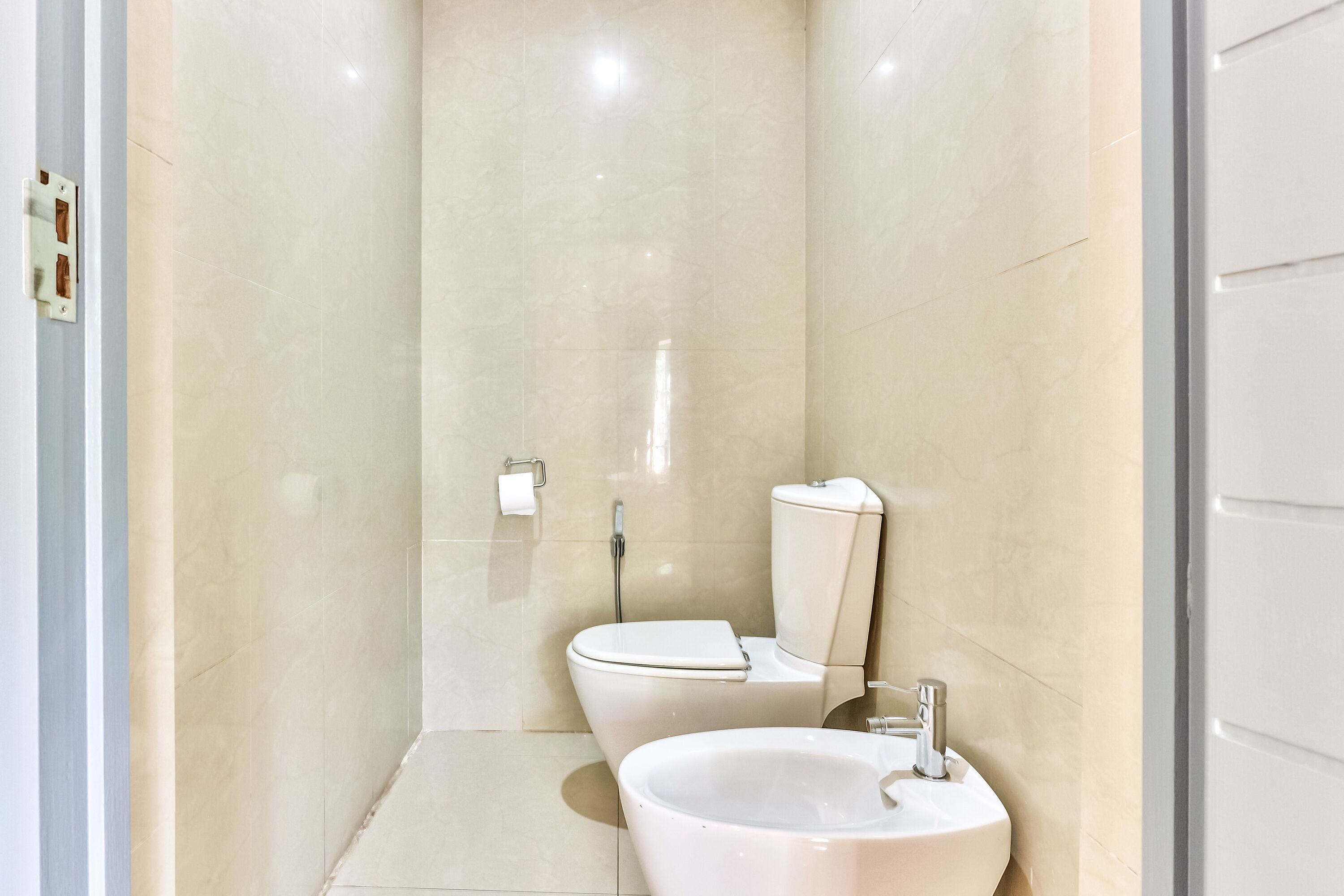 A bathroom with a toilet, bidet, and sink.