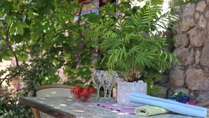 A table with a bowl of strawberries, a decorative vase, and a rolled-up mat. - Apartment Lile (Dubrovnik)