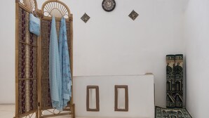 Ein Gebetsraum mit einer Holzwand, Gebetsmatten und einer Uhr an der Wand.