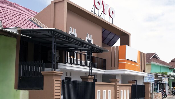 Ein Gebäude mit einem gut sichtbaren 'OYO'-Schild, einem schmiedeeisernen Eingang und einem überdachten Balkon.