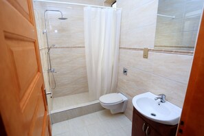 A bathroom with a shower, toilet, and sink. - Bon Bini Residence Muyenga Bukasa Kampala- Uganda (Kampala)