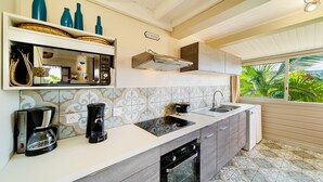 A kitchen with a built-in stove, a coffee maker, and a sink.