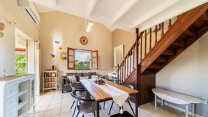 A dining area with a wooden table, chairs, and a staircase.