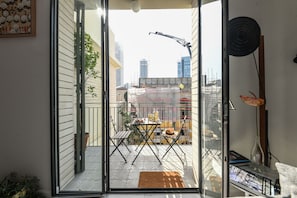 Relax on the balcony with a sofa, coffee table, and potted plant.