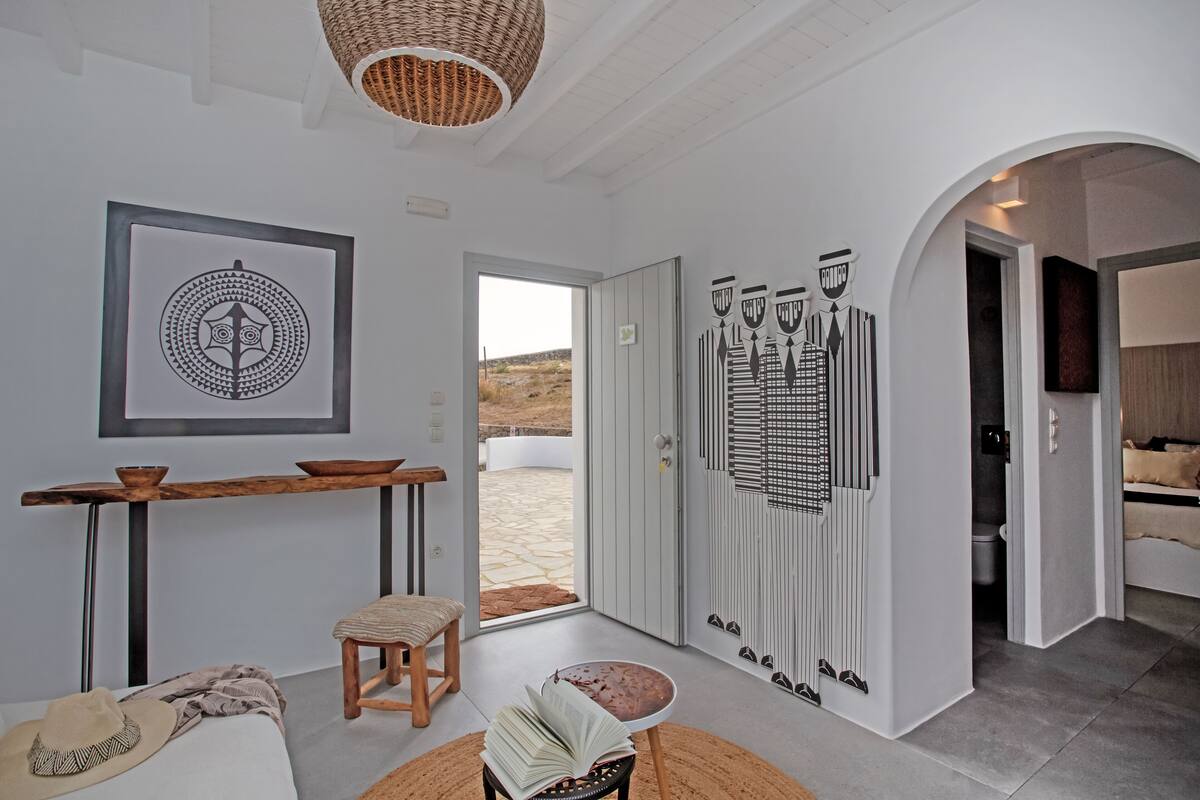 A modern interior with a dining area, a bookshelf, and a view of the outdoors.