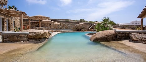 Alberca al aire libre por temporada y sombrillas en la alberca