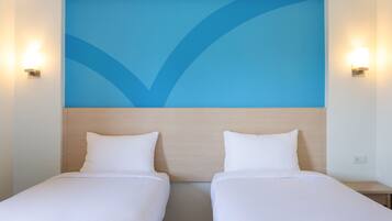 Een hotelkamer met twee eenpersoonsbedden, een houten hoofdbord en een blauw abstract ontwerp op de muur.