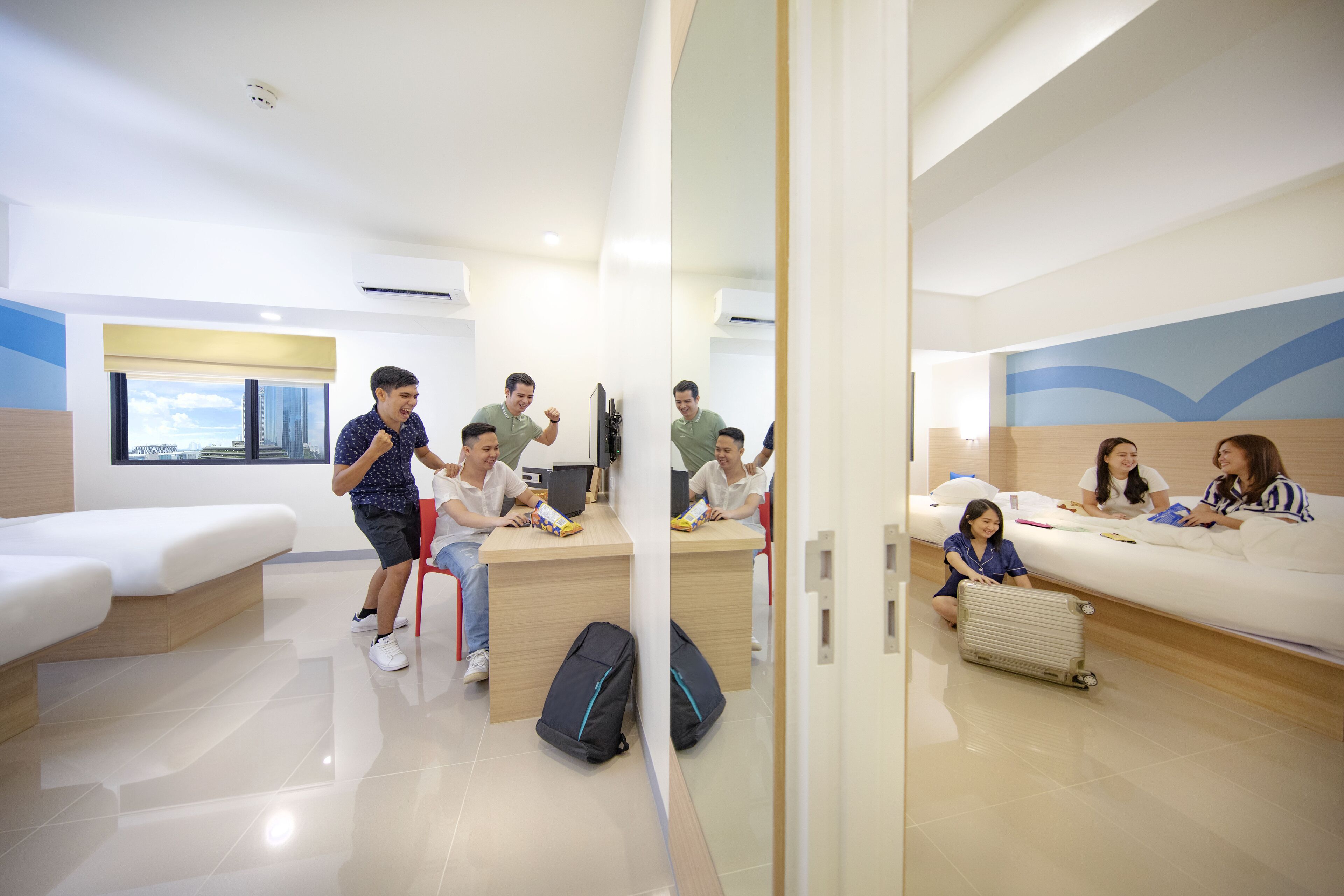 A modern hotel room with a large bed, a desk, and a seating area.