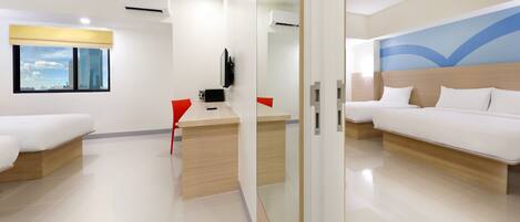 A modern hotel room with a bed, bedside tables, a desk, a chair, and a TV.