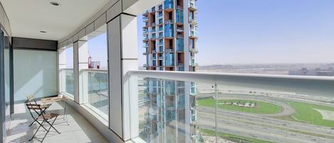 Un balcon donnant sur un immeuble de grande hauteur et une autoroute.