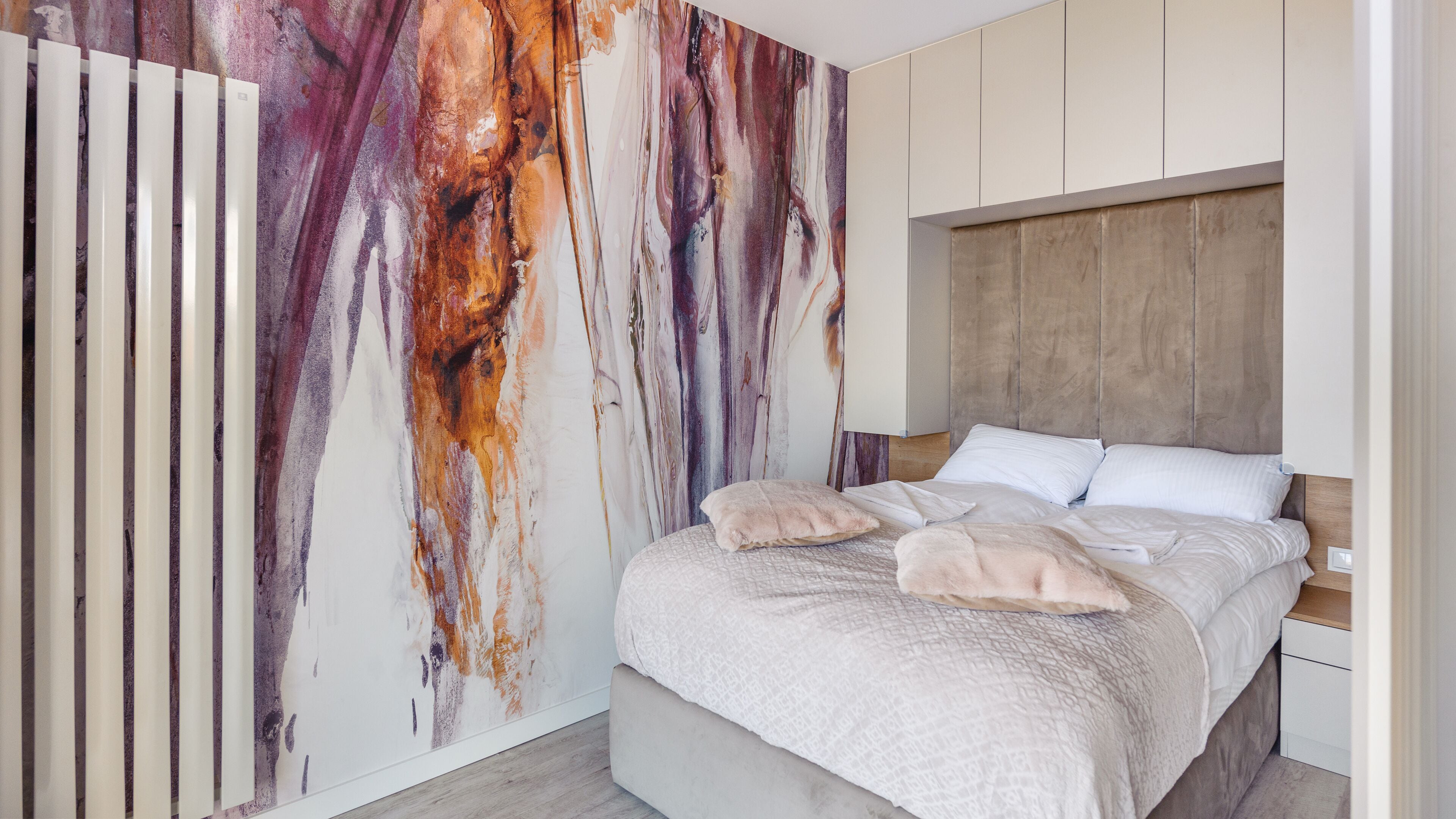 Ein modernes Schlafzimmer mit einem großen Bett, einem Holzkopfende und einer Wand mit Marmordesign.