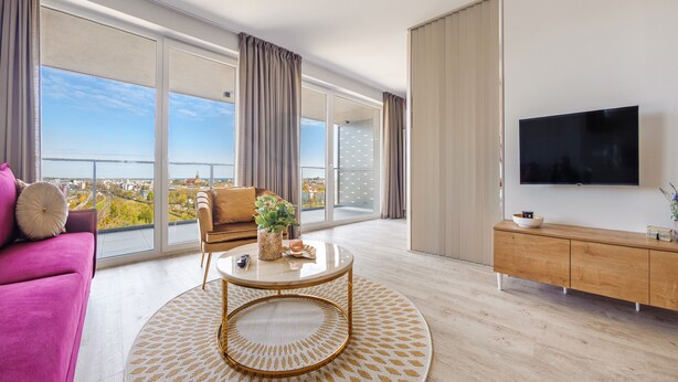 A modern living room with a sofa, a coffee table, and a TV. - Apartamenty Sun&Snow Modern Tower (Gdynia)