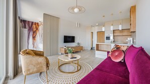 A modern living room with a sofa, armchair, and a round coffee table. - Apartamenty Sun&Snow Modern Tower (Gdynia)