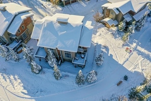 A snow-covered residential area with houses, some with attached garages, and a few trees. - Location, Location, Location! Ski in Ski out at Trapper's Landing #23 (Sun Peaks)