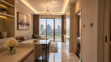 A modern living room with a sofa, a dining table, and a view of the cityscape through large windows.