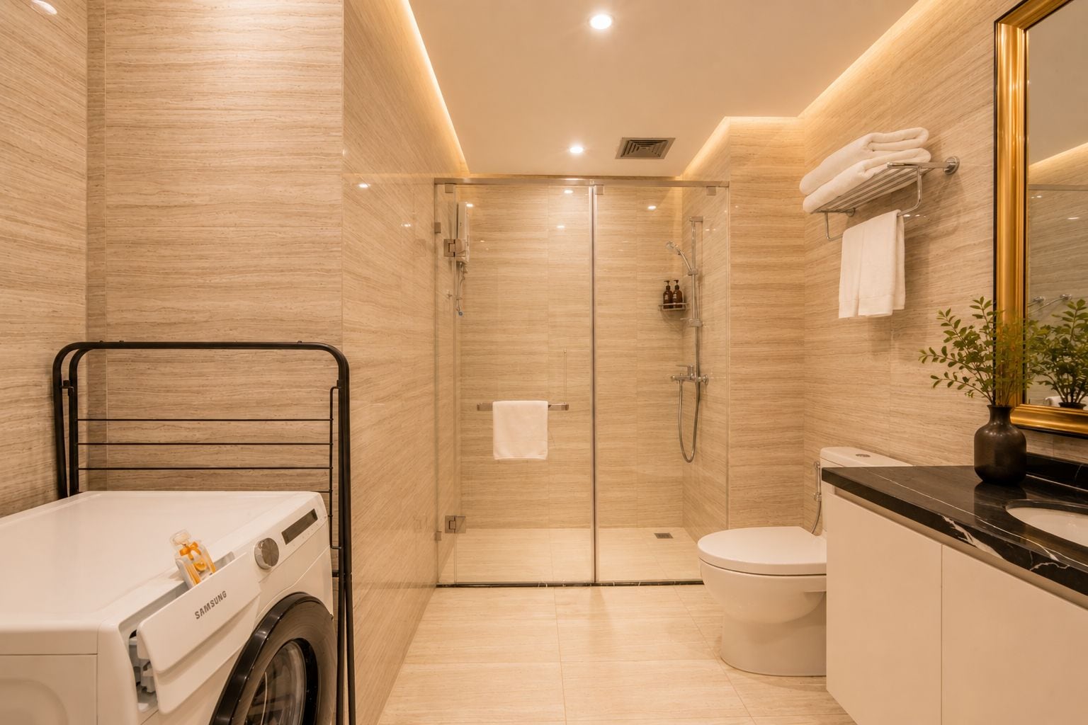 A modern bathroom with a glass-enclosed shower, a toilet, and a washing machine.
