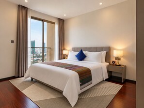 A hotel room with a large bed, two bedside lamps, a view of the city through the window, and a cityscape visible outside.