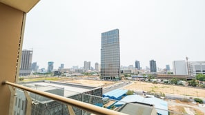 A cityscape with a prominent modern skyscraper, a construction site, and a mix of residential and commercial buildings. - Soladia Hotel & Residences by One Park (Phnom Penh)