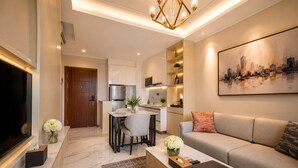 A modern living room with a sofa, coffee table, and a painting of a cityscape. - Soladia Hotel & Residences by One Park (Phnom Penh)