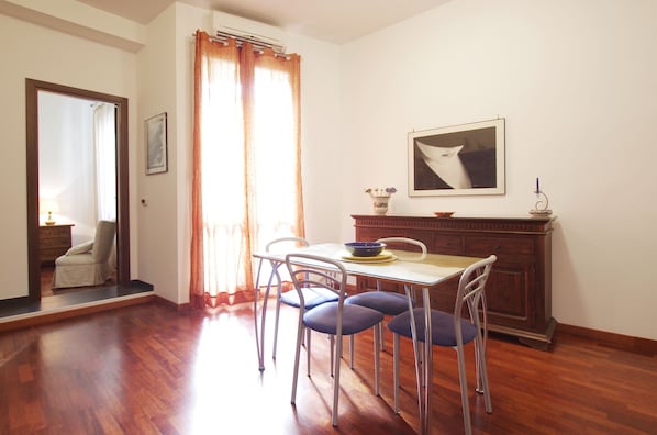 A dining area with a table, chairs, and a cabinet.